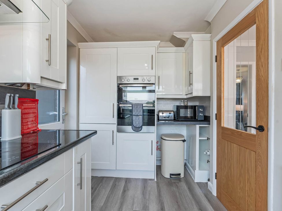 A kitchen with appliances and cabinets at The Old Barn in Stafford