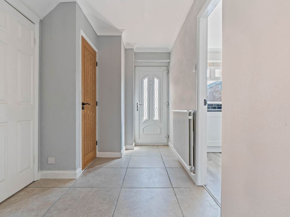 A hallway with doors and a radiator at The Old Barn in Stafford