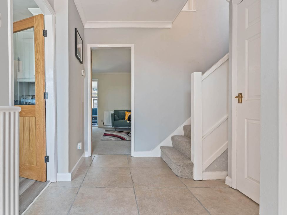 A hallway with a staircase and door at The Old Barn in Stafford