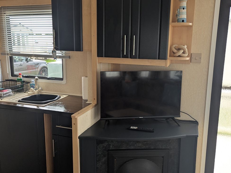 A kitchen with a sink and television at 