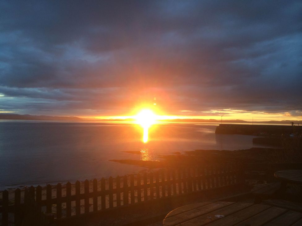 A sunset over water at PetFriendly Beachfront Sunset Facing Porch Garden in Portmahomack