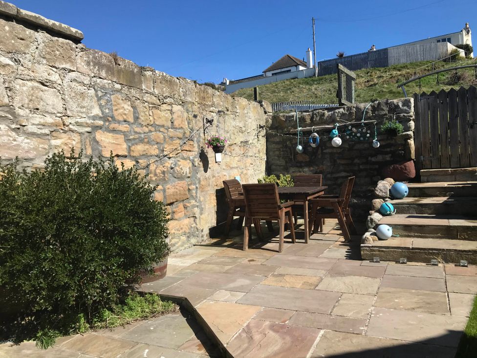 An outdoor garden with a table and chairs at PetFriendly Beachfront Sunset Facing Porch Garden, Portmahomack