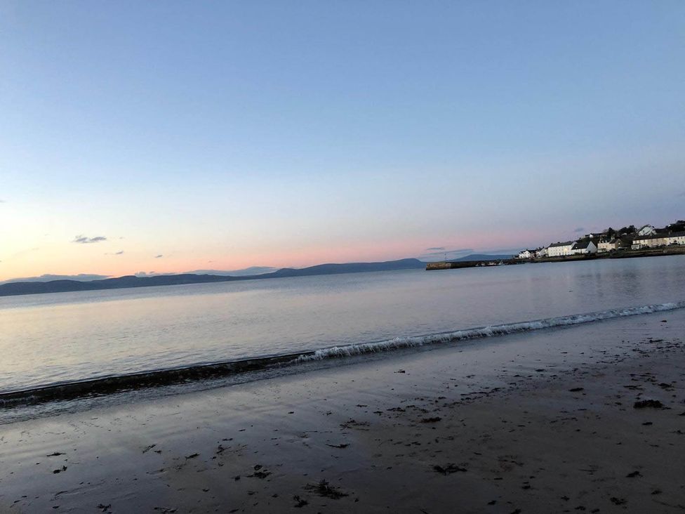 A beach with sea and houses at PetFriendly Beachfront Sunset Facing Porch Garden, Portmahomack