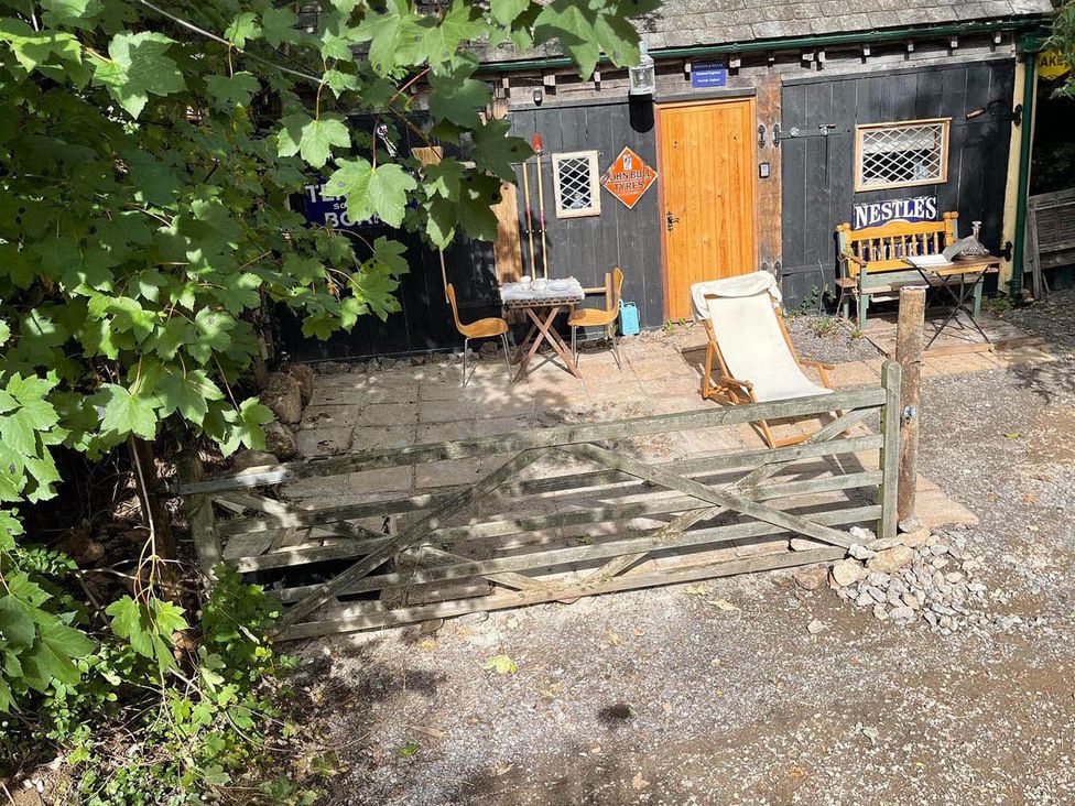 An outdoor area with a gate, chairs, and tables at a building in Bovey Tracey