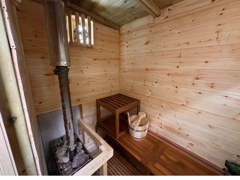 A sauna with wooden walls and a stove at 