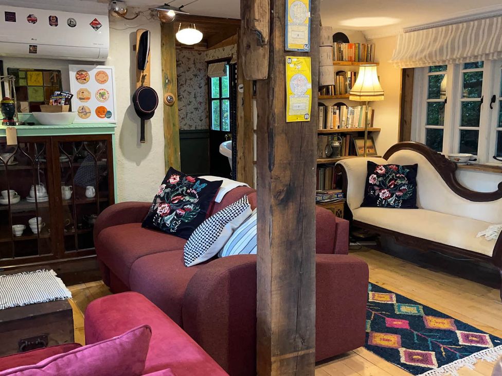 A living room with sofas and a bookshelf at  in Bovey Tracey