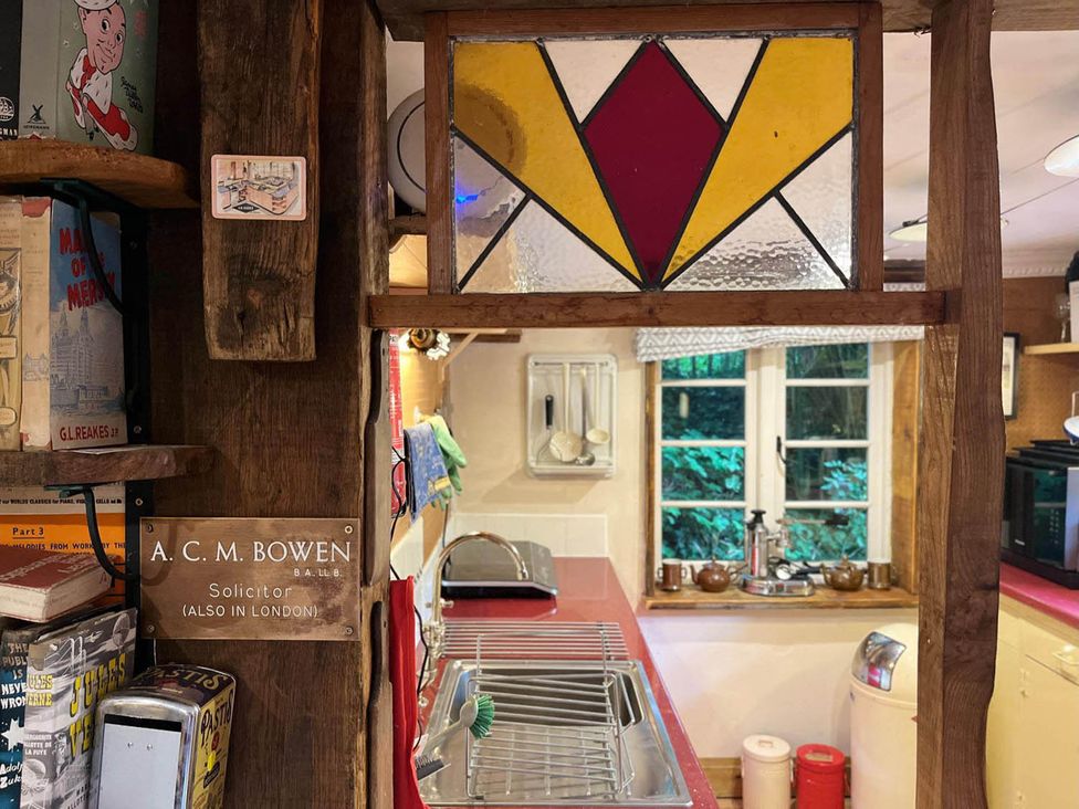 A kitchen with a stained glass window and sink at The Old Barn in Bovey Tracey