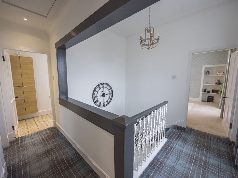 A hallway with a clock and chandelier at Short Walk to the Beach - 2 Guests - Free Parking in Thurso