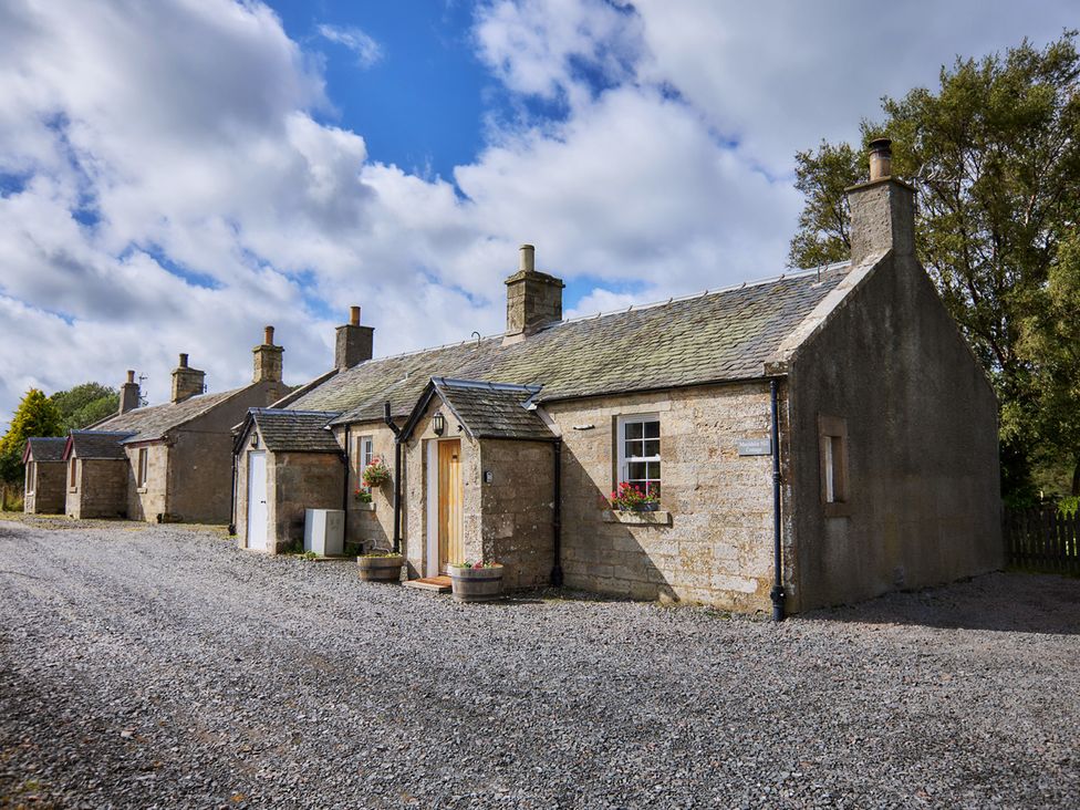 A view of multiple cottages with a gravel driveway near Edinburgh