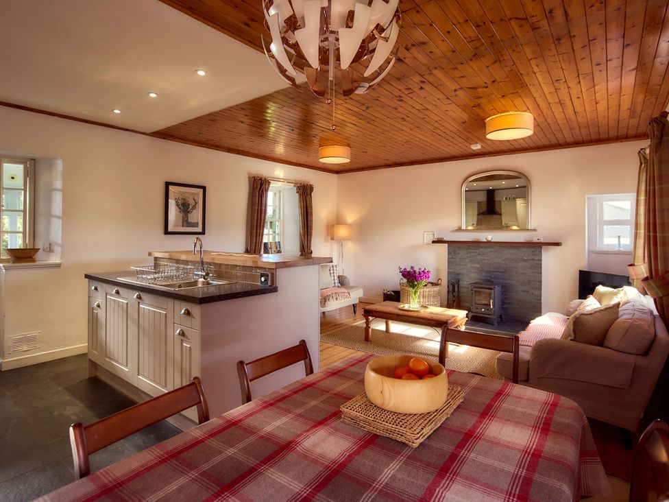 A living room with a dining area and kitchen island at The Old Barn near Edinburgh