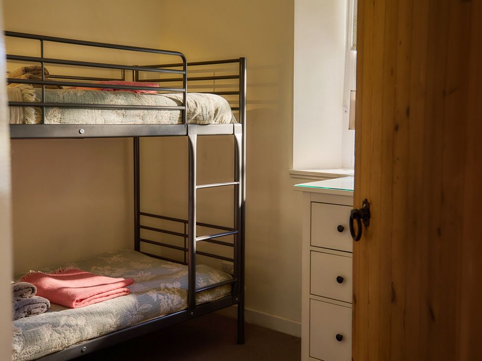 A bedroom with a bunk bed and a drawer unit near Edinburgh