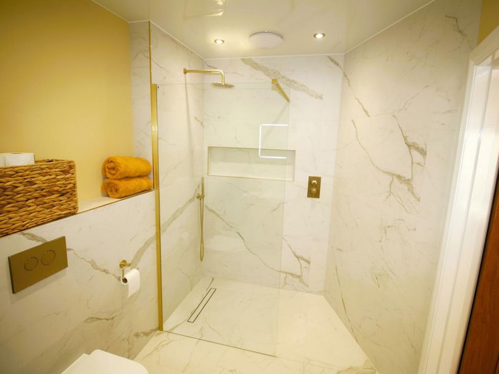 A bathroom featuring a shower, towels, and a toilet at Newly Refurbished Cottage, sleeping 4 and Central Berwick-Upon-Tweed