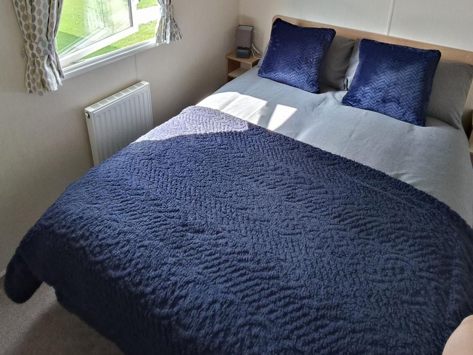 A bedroom with a bed and pillows at Golden Sands 3-Bed Caravan, Parking and Pet Friendly in Towyn