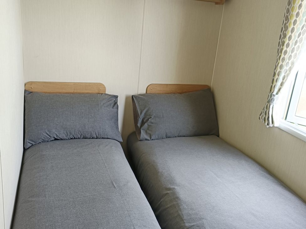 A bedroom with two single beds at Golden Sands 3-Bed Caravan, Parking and Pet Friendly in Towyn