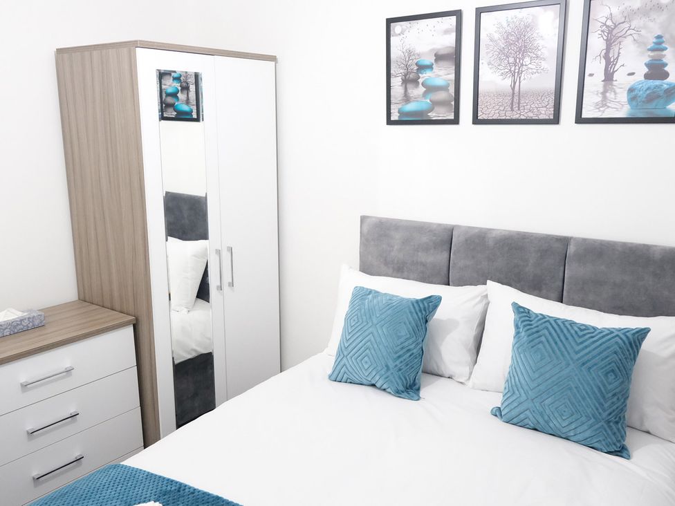 A bedroom with a bed and wardrobe at 3 Bedroom, Modern House in Manchester