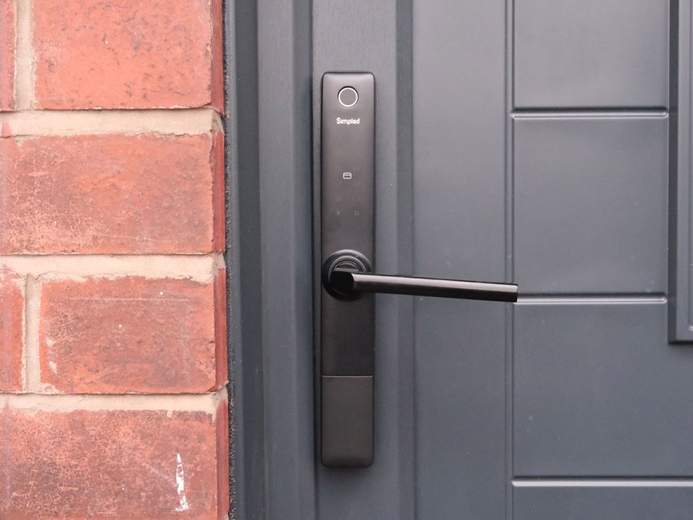 A smart lock and door handle on a black door