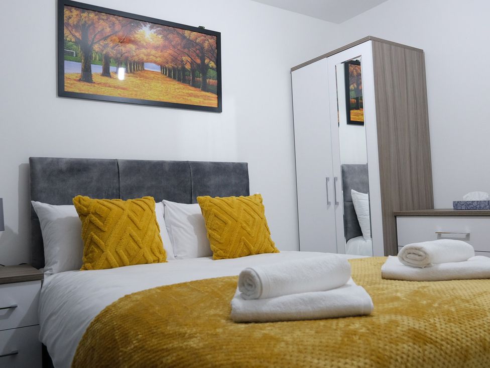 A bedroom with a bed and wardrobe at 3 Bedroom, Modern House in Manchester