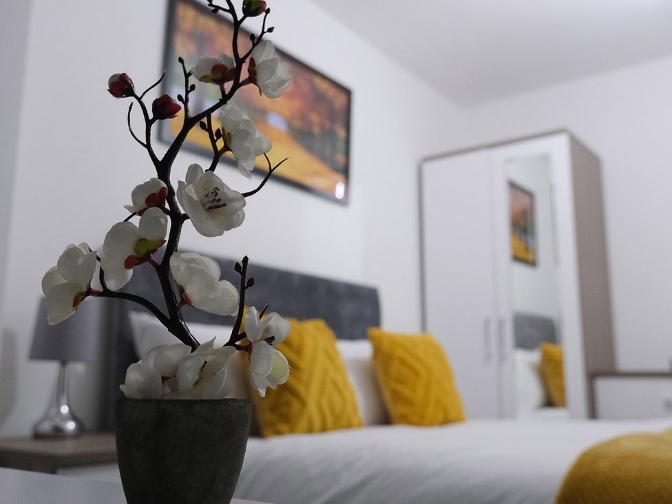A bedroom with a bed and decorative elements at 3 Bedroom, Modern House in Manchester