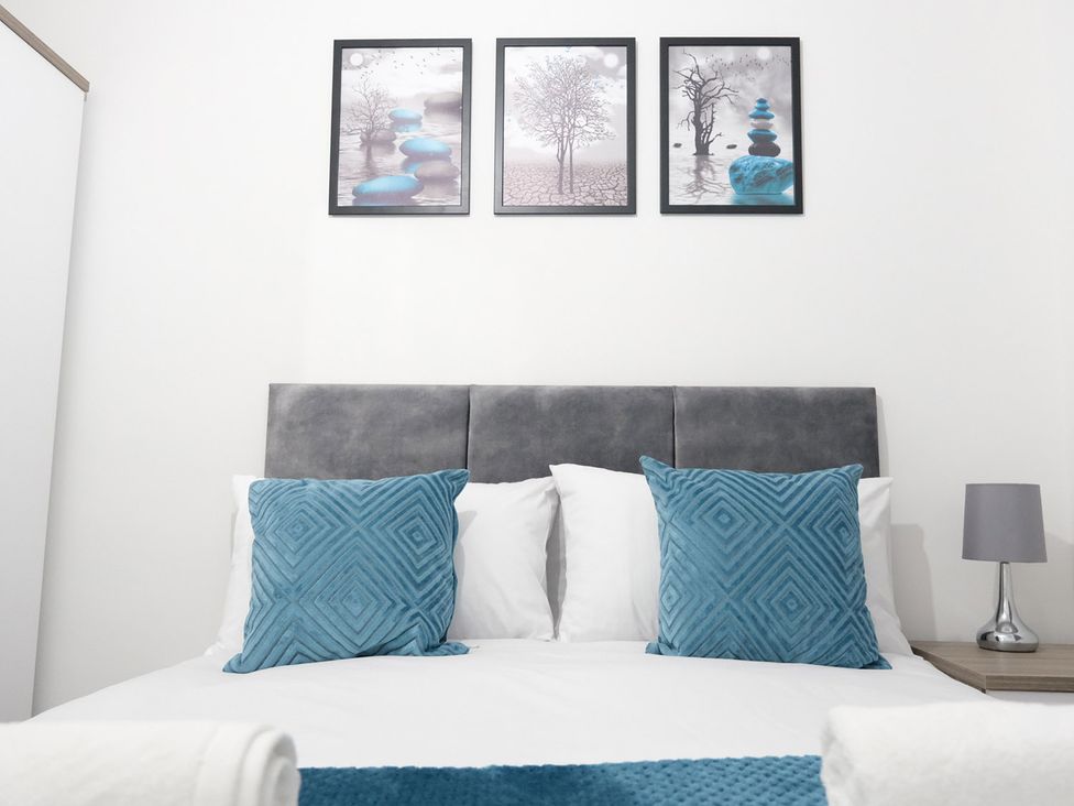 A bedroom with a bed and decorative pillows at 3 Bedroom, Modern House in Manchester