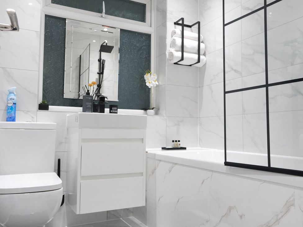 A bathroom with a toilet, sink, and bathtub at 3 Bedroom, Modern House in Manchester