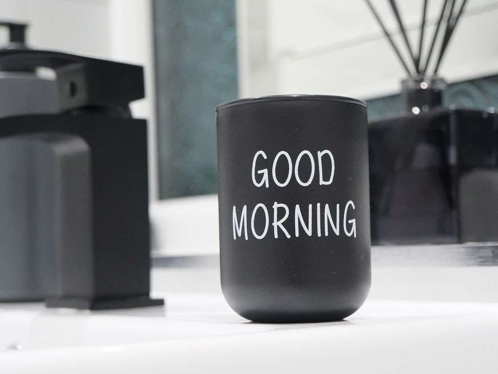 A mug with text on a bathroom countertop at 3 Bedroom, Modern House in Manchester