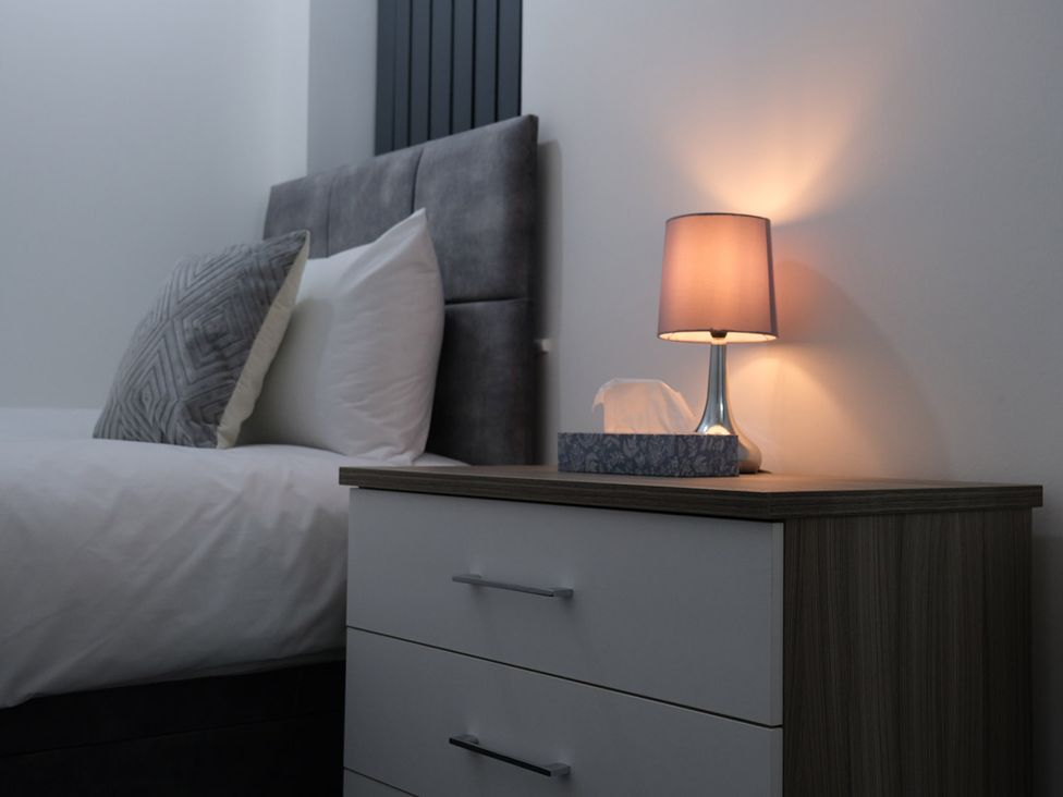 A bedroom with a bed and nightstand at 3 Bedroom, Modern House in Manchester