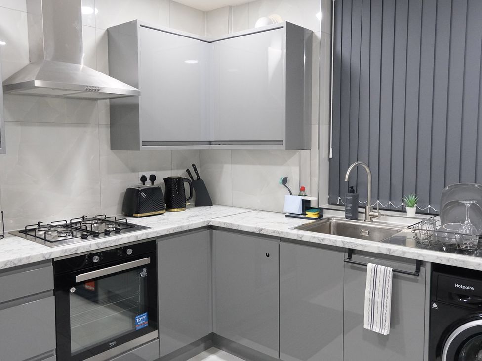A kitchen with appliances and cabinets at 3 Bedroom, Modern House in Manchester