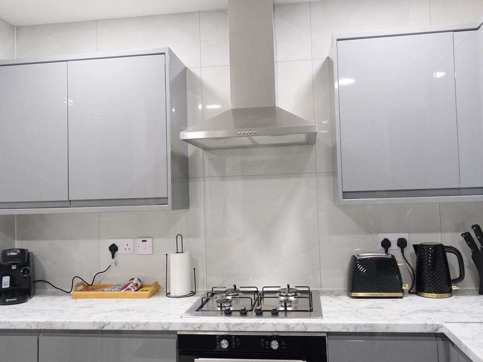 A kitchen with cabinets, appliances, and countertop at 3 Bedroom, Modern House in Manchester