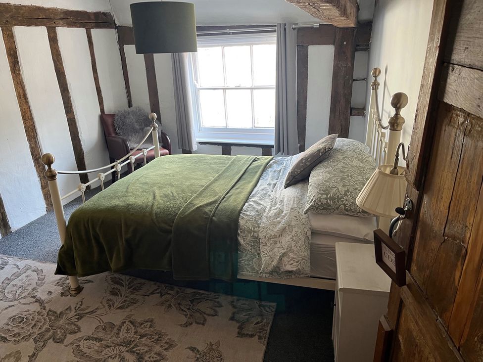 A bedroom with a bed, chair, and window at Historic Cottage on the Suffolk border, Harleston Norfolk