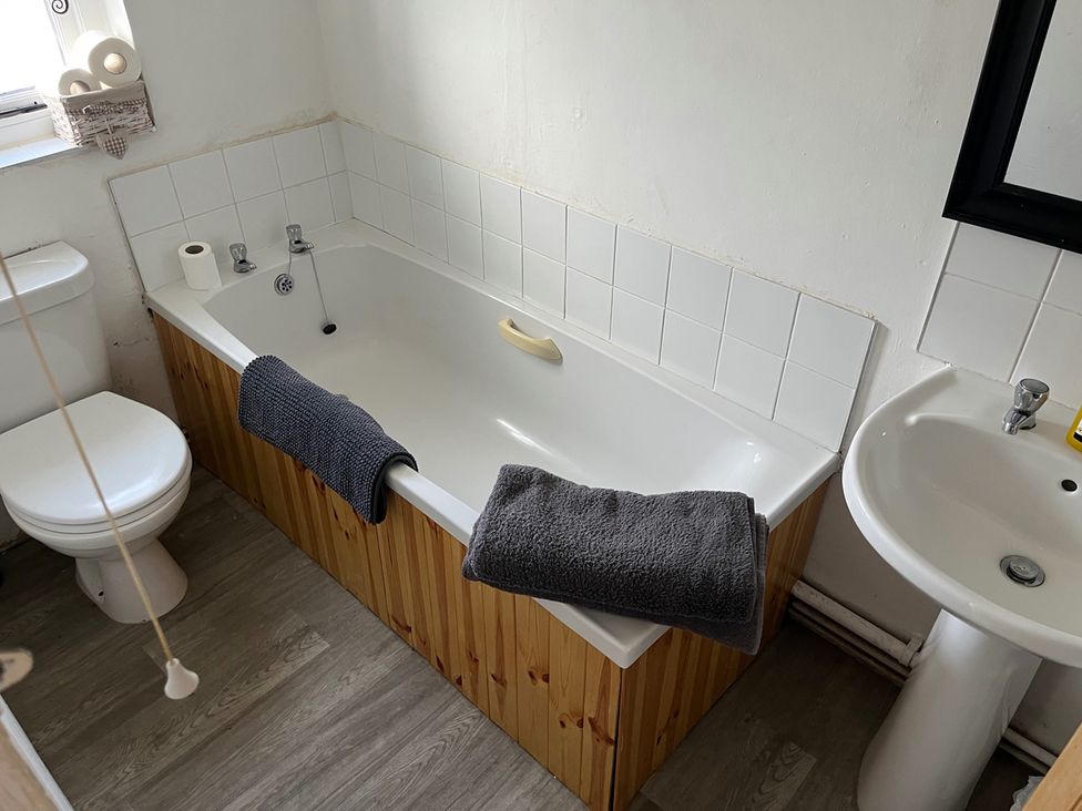 A bathroom with a bathtub, toilet, and sink at Historic Cottage on the Suffolk border, Harleston Norfolk