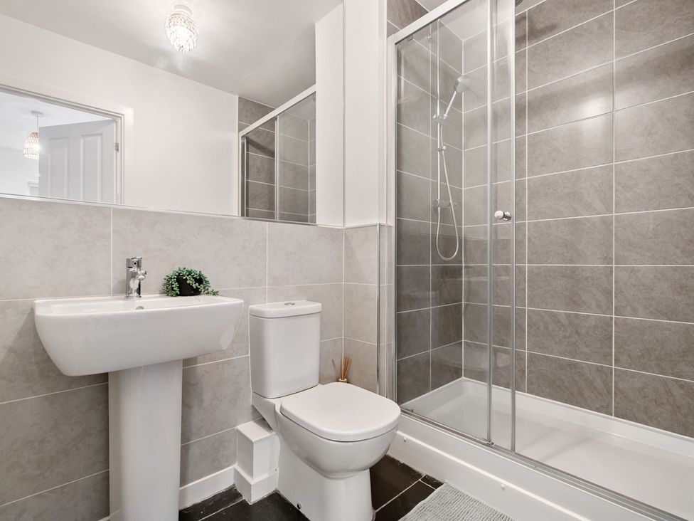 A bathroom with a wash basin, toilet and shower at House, sleeping 4 with Garden and Parking Ashford