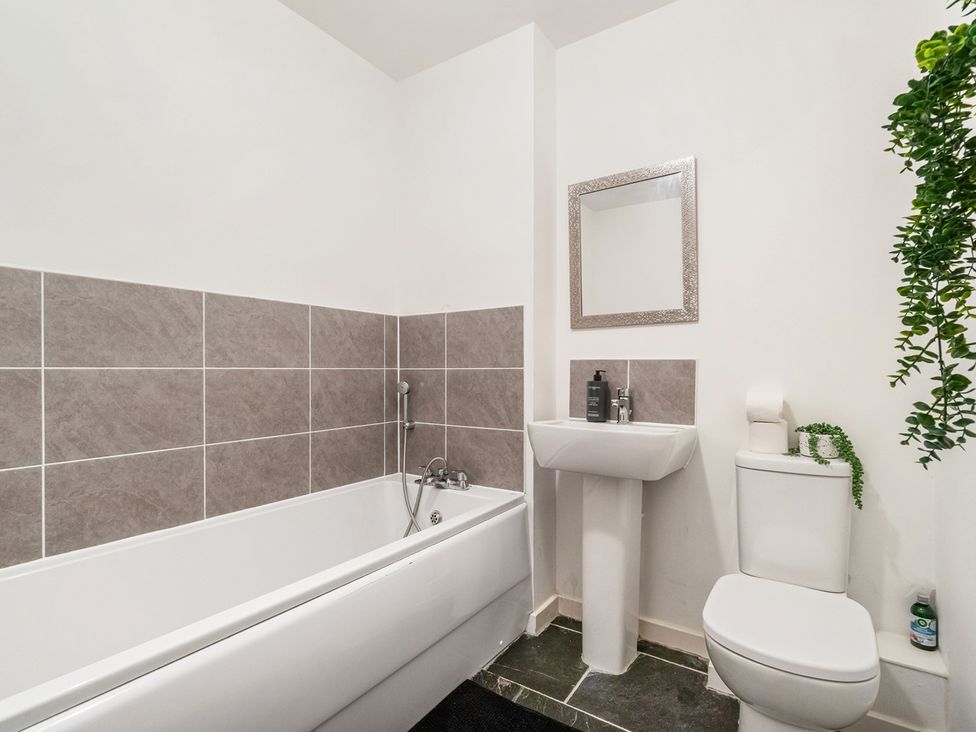 A bathroom with a bathtub, sink, and toilet at House, sleeping 4 with Garden and Parking Ashford
