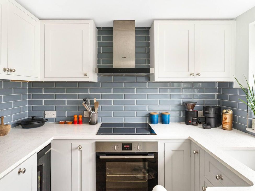A kitchen with cabinets, a cooktop, and a coffee maker at Little Braybrooke Cottage- Saffron Walden