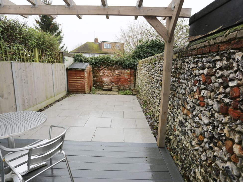 A garden with a shed and stone wall at Little Braybrooke Cottage- Saffron Walden
