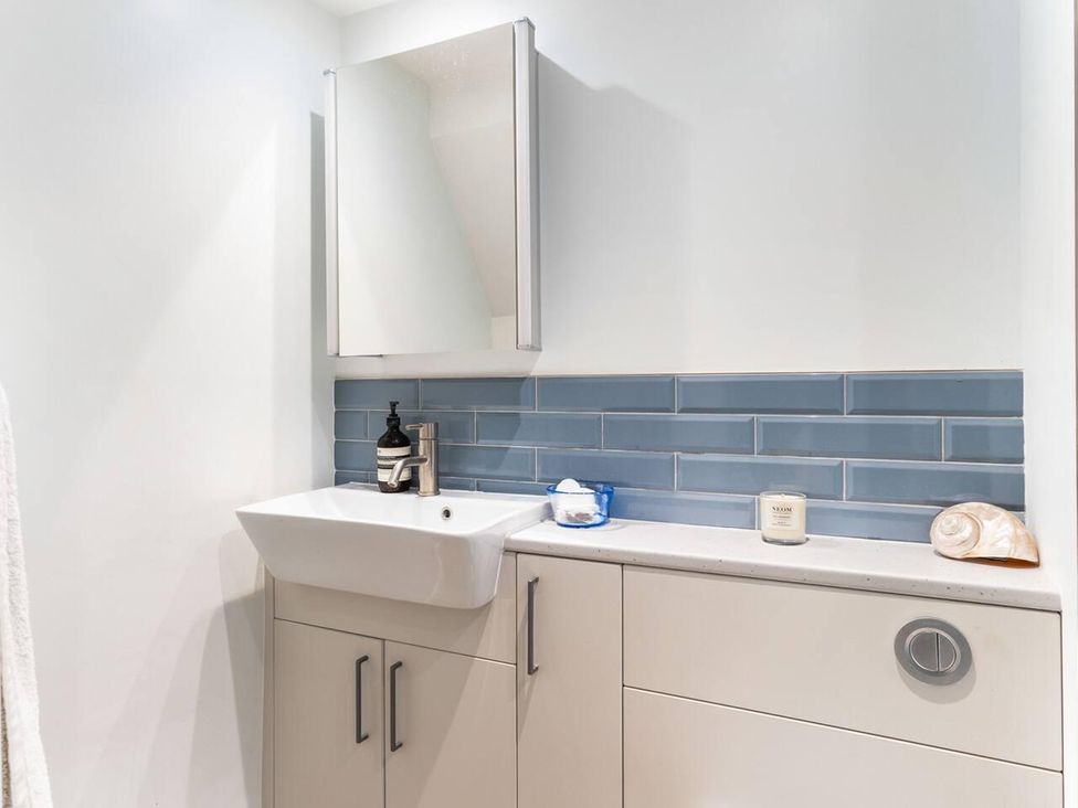 A bathroom with a sink, mirror and storage cabinet at Little Braybrooke Cottage- Saffron Walden
