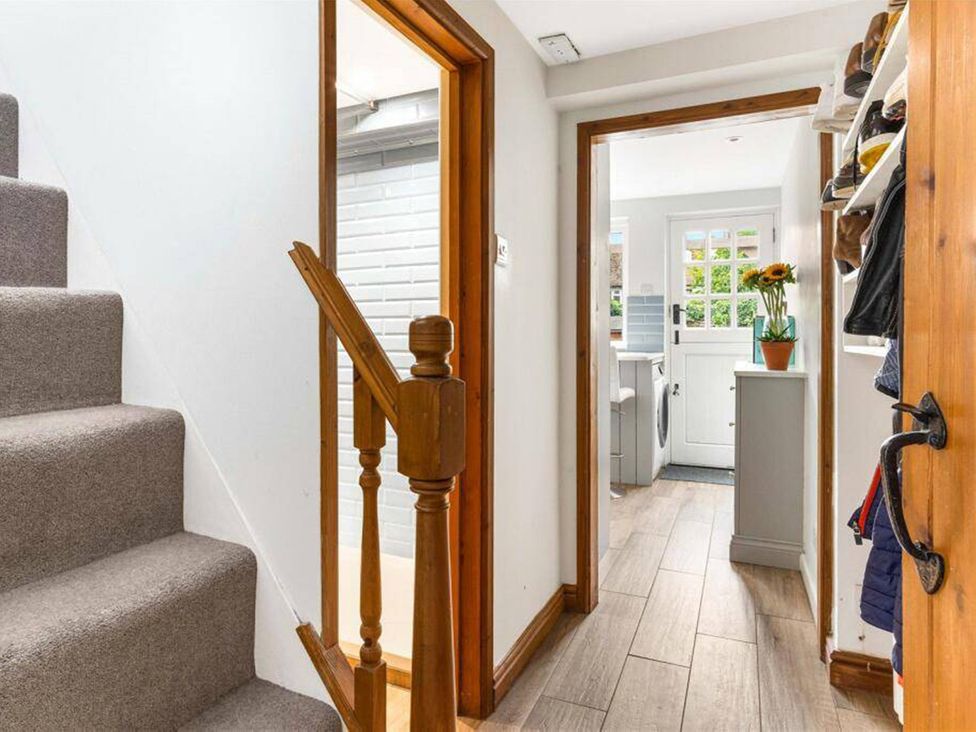 A hallway with stairs and doorways at Little Braybrooke Cottage- Saffron Walden
