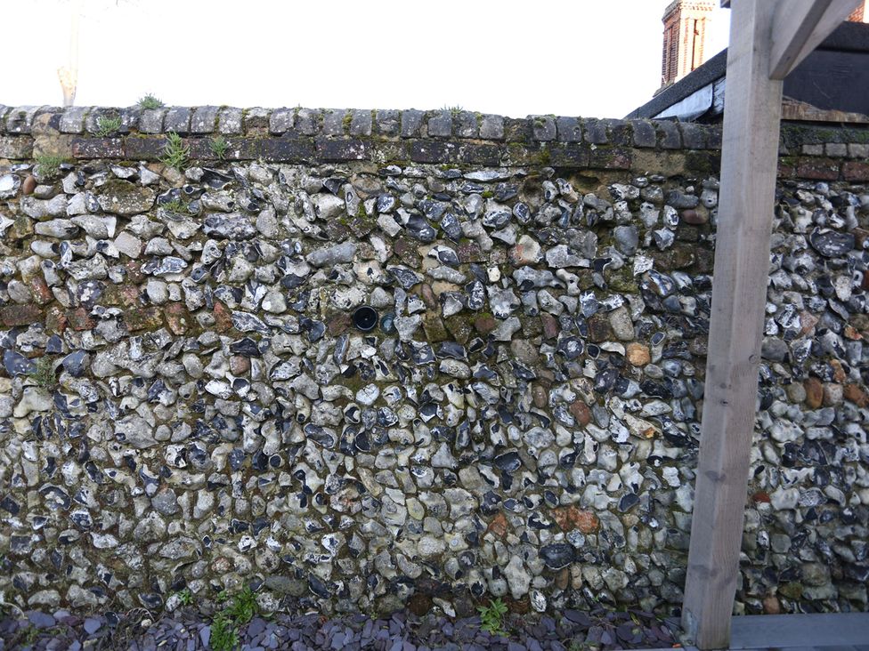 A wall made of flint stones with moss at Little Braybrooke Cottage- Saffron Walden