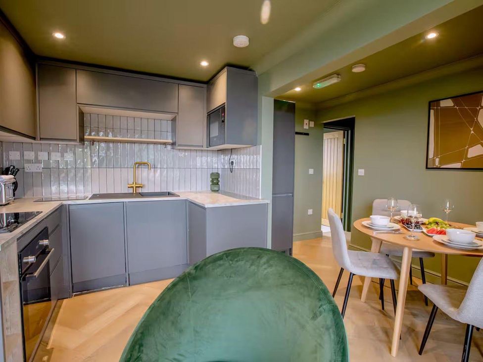 A kitchen with appliances and dining area at 1 Bedroom Apartment, sleeping 3 with balcony and pet friendly, Carbis Bay