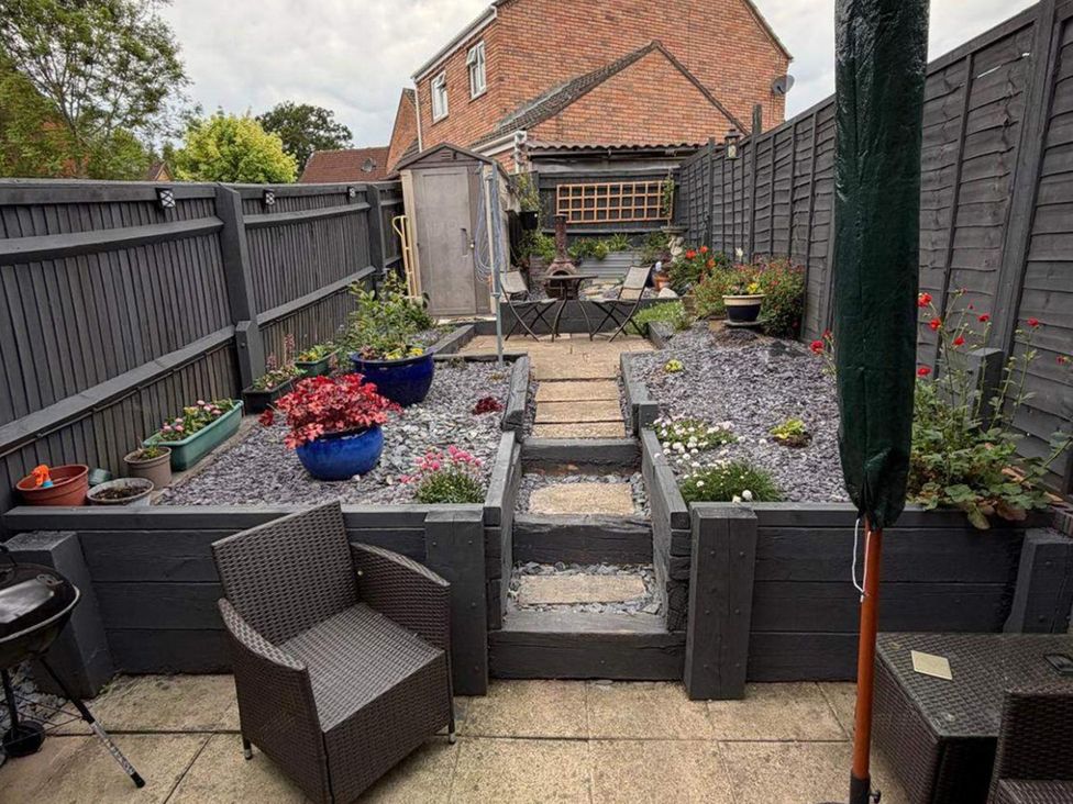 A garden with flower pots and seating area at Sleeps 5 pet friendly, Enclosed garden, Parking in Belmont near Hereford