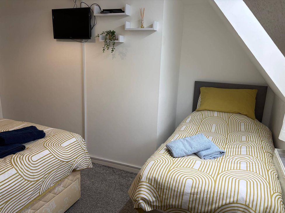 A bedroom with two beds and a TV at Sleeps 5 pet friendly, Enclosed garden, Parking Belmont near Hereford
