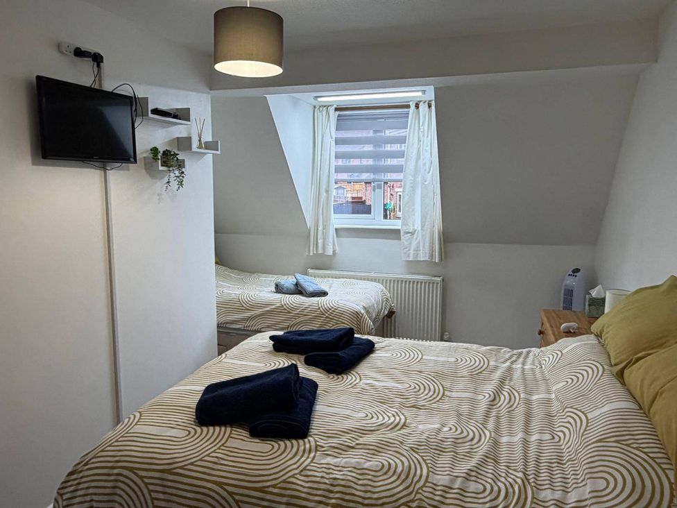 A bedroom with two beds and a television at Sleeps 5 pet friendly, Enclosed garden, Parking in Belmont near Hereford