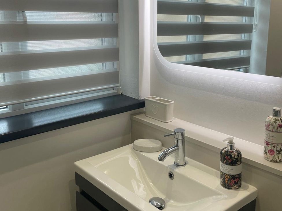 A sink with faucet and soap dispensers in a bathroom at Sleeps 5 pet friendly, Enclosed garden, Parking, Belmont near Hereford