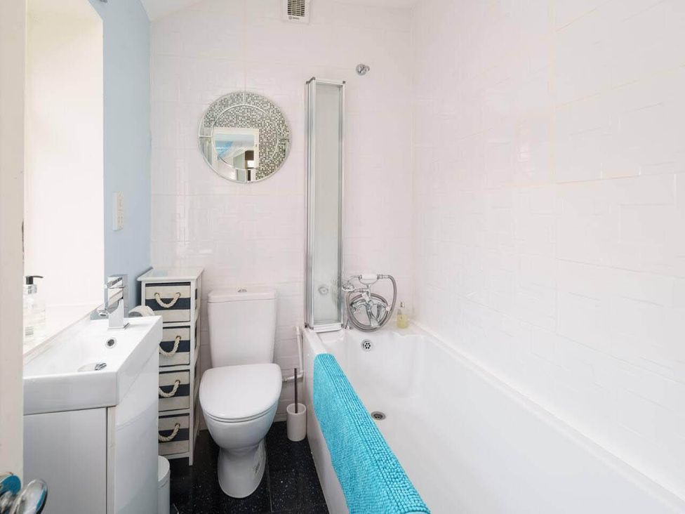 A bathroom with a bath tub, toilet, sink and mirror at Impeccable 3 bed 2 bath Central Cowes Cottage, Cowes