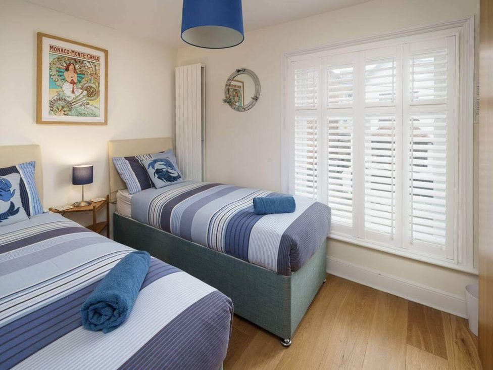 A bedroom with two single beds and a mirror at Impeccable 3 bed 2 bath Central Cowes Cottage Cowes