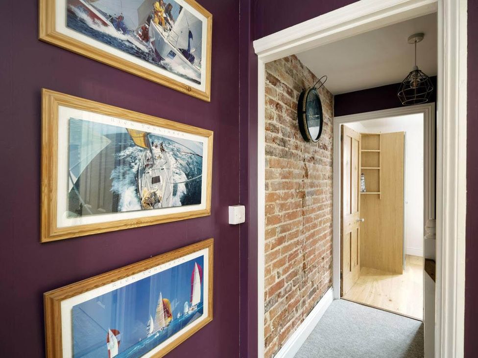A hallway with sailing pictures on the wall at Impeccable 3 bed 2 bath Central Cowes Cottage, Cowes