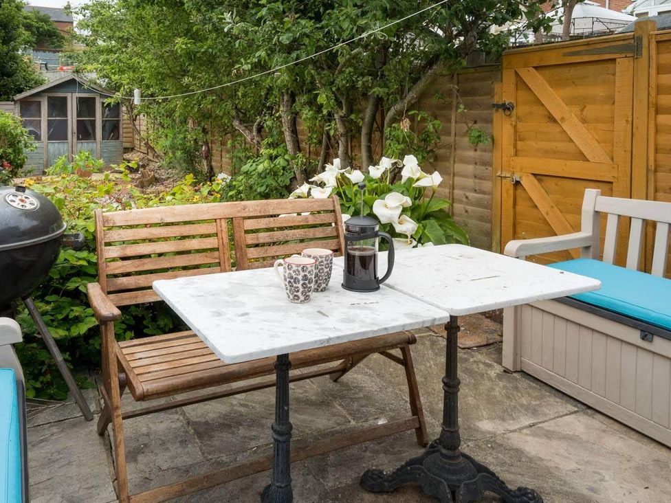 A garden with a table and benches at Impeccable 3 bed 2 bath Central Cowes Cottage in Cowes