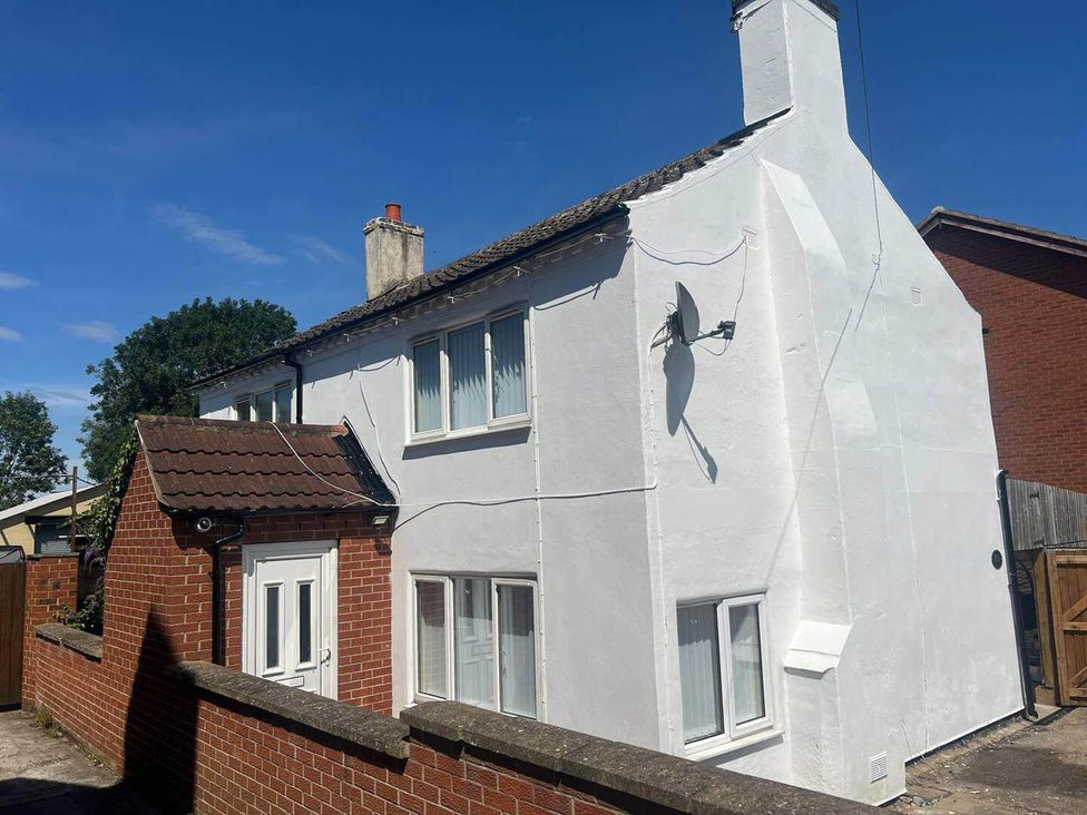 A house with white exterior and satellite dish at Blyton 2-Bed Cottage, Parking, 30m to Lincoln, Gainsborough