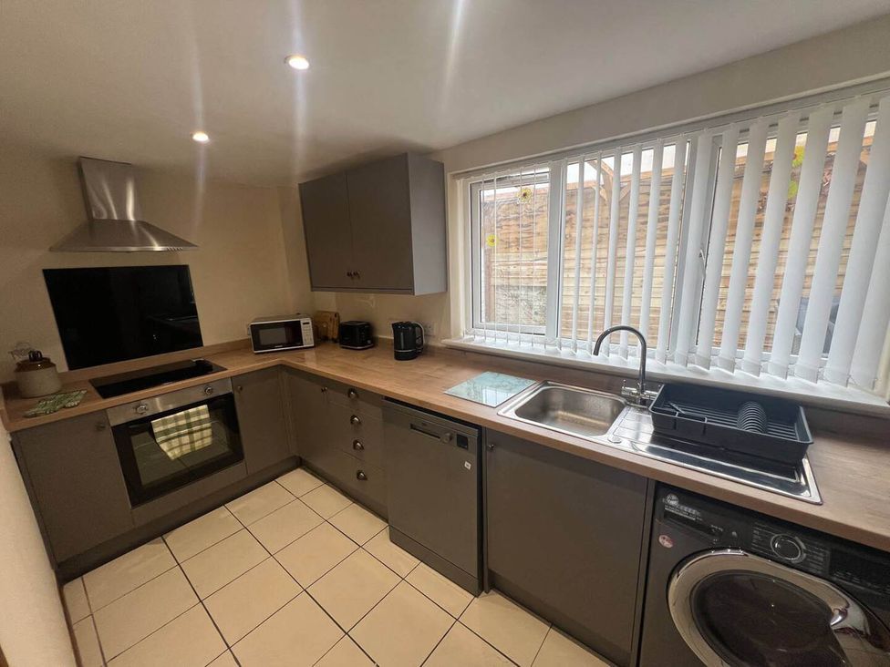 A kitchen with various appliances and a sink at Blyton 2-Bed Cottage, Parking, 30m to Lincoln in Gainsborough