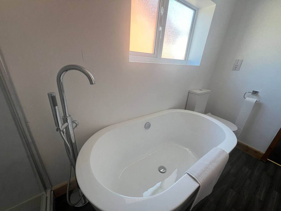 A bathroom with a bathtub and toilet at Blyton 2-Bed Cottage, Parking, 30m to Lincoln in Gainsborough