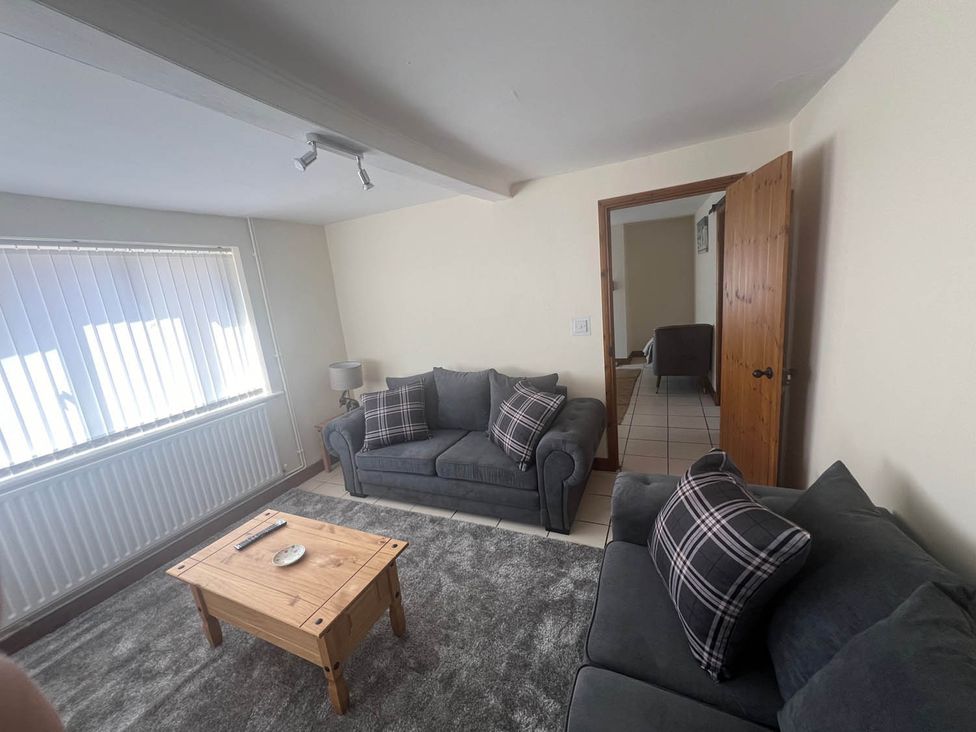 A living room with a sofa, table, and lamp at Blyton 2-Bed Cottage, Parking, 30m to Lincoln in Gainsborough